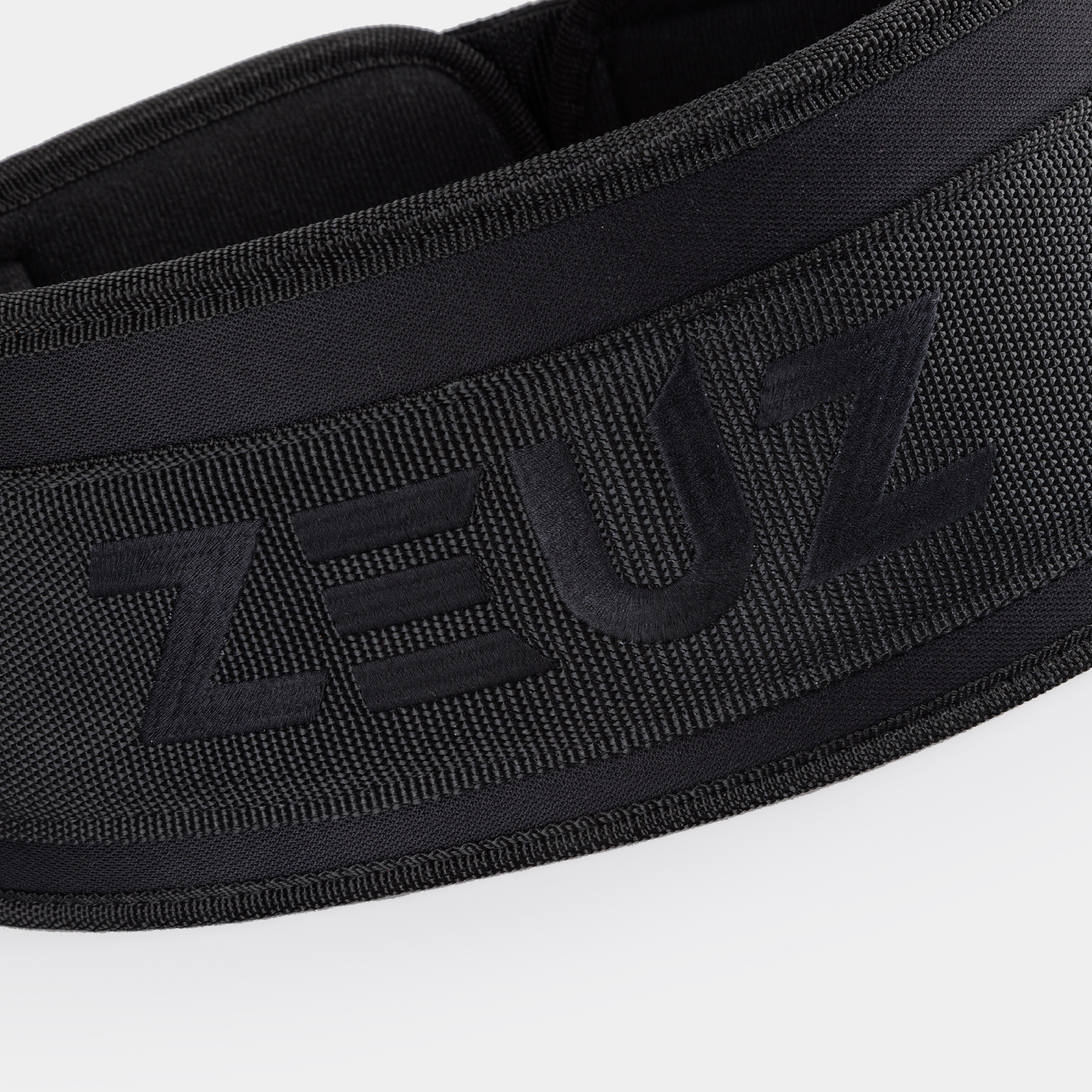 Close-up van het geborduurde ZEUZ logo op de gewichthefriem zwart