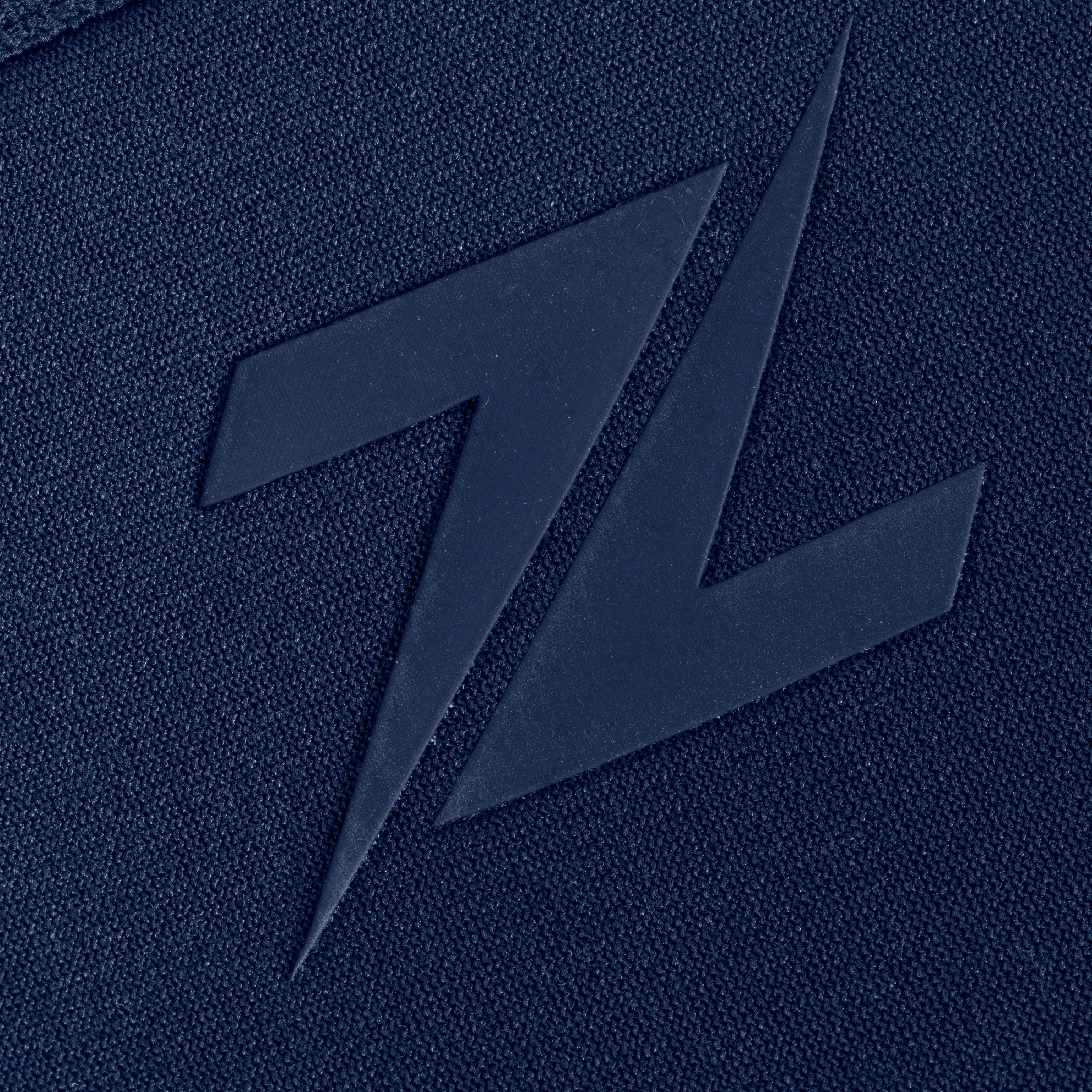 Close-up van het ZEUZ logo op de blauwe knee sleeves – premium afwerking voor sporters